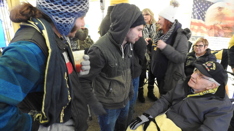 rosnyai talking with people in tent