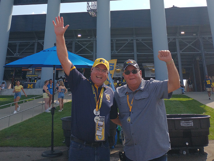 Tom outside stadium with friend